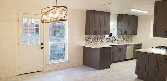 412 Ellis St, Allen, TX 75002 - kitchen with stainless steel dishwasher, a chandelier, light countertops, a sink, and tasteful backsplash