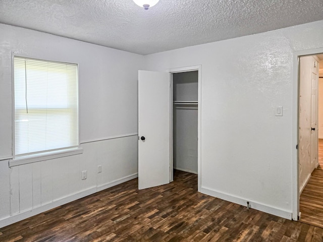 1155 Clay St, Canton, TX 75103 - unfurnished bedroom featuring dark wood-type flooring, a textured ceiling, a closet, and baseboards