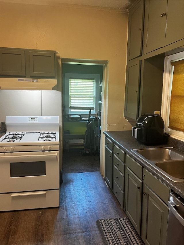 544 N Clinton St, Stephenville, TX 76401 - kitchen featuring white range with gas stovetop, stainless steel dishwasher, dark countertops, a sink, and under cabinet range hood