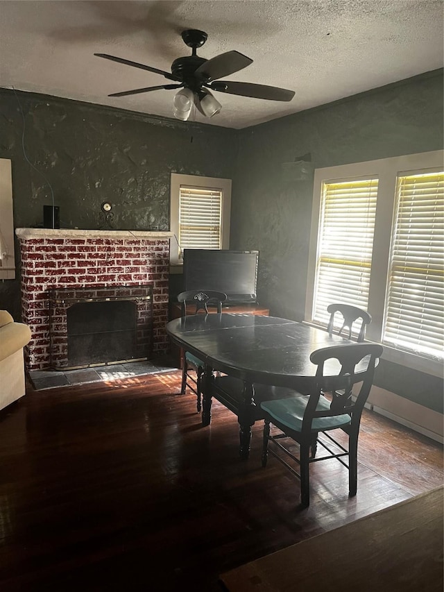 544 N Clinton St, Stephenville, TX 76401 - dining space with wood finished floors, ceiling fan, a brick fireplace, and a textured ceiling