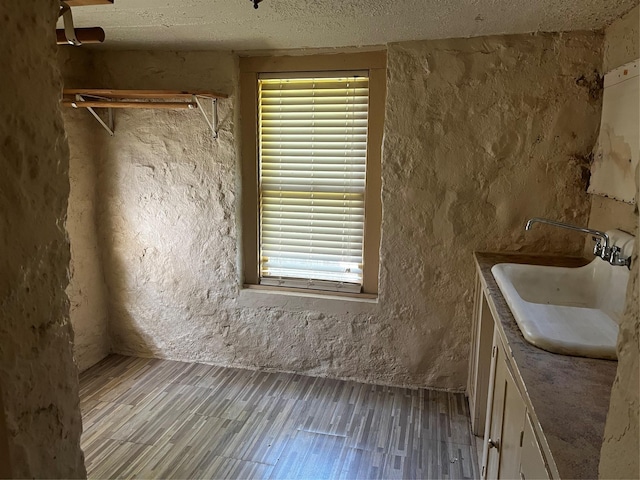 544 N Clinton St, Stephenville, TX 76401 - bathroom featuring vanity, a textured ceiling, wood finished floors, a textured wall, and healthy amount of natural light