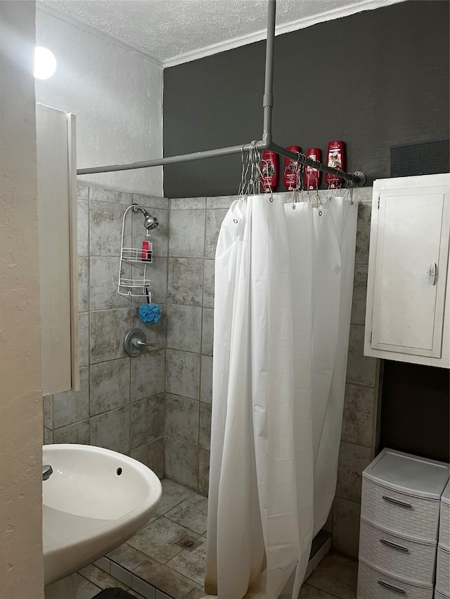 544 N Clinton St, Stephenville, TX 76401 - bathroom with tiled shower, electric panel, a textured ceiling, a sink, and a textured wall