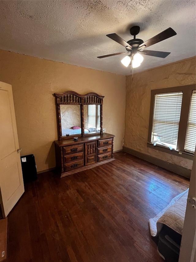 544 N Clinton St, Stephenville, TX 76401 - unfurnished bedroom featuring wood finished floors, a textured ceiling, a textured wall, ceiling fan, and baseboards