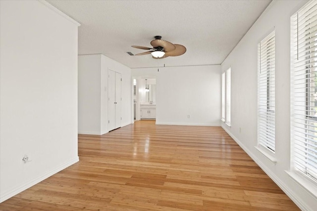 310 Naples Dr, Duncanville, TX 75116 - spare room featuring a textured ceiling, ceiling fan, light wood finished floors, and baseboards