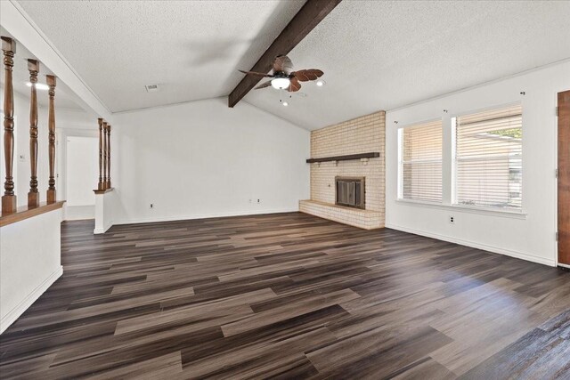 310 Naples Dr, Duncanville, TX 75116 - unfurnished living room featuring ceiling fan, dark wood finished floors, a textured ceiling, a brick fireplace, and baseboards