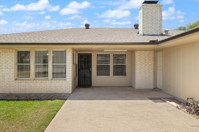 310 Naples Dr, Duncanville, TX 75116 - property entrance featuring brick siding, a chimney, and a shingled roof