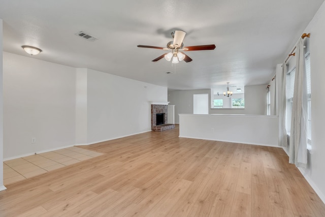 812 Piedmont Dr, Mckinney, TX 75071 - unfurnished living room featuring light wood finished floors, ceiling fan, a chandelier, a fireplace, and baseboards
