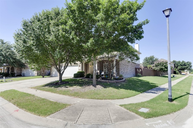 115 Roundup Rd, Waxahachie, TX 75165 - view of property hidden behind natural elements with driveway, brick siding, a front yard, a chimney, and an attached garage
