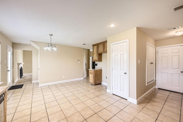 117 Parkview Dr, Saginaw, TX 76179 - kitchen featuring light tile patterned floors, brown cabinetry, decorative light fixtures, baseboards, and recessed lighting