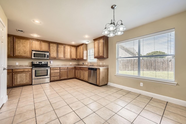 117 Parkview Dr, Saginaw, TX 76179 - kitchen with appliances with stainless steel finishes, light countertops, brown cabinets, a chandelier, and hanging light fixtures