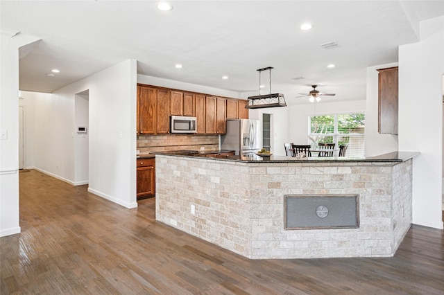 841 Brittany Way, Prosper, TX 75078 - kitchen featuring stainless steel appliances, a ceiling fan, dark wood-style flooring, dark countertops, and brown cabinetry