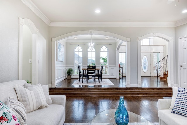 124 Lonesome Trl, Haslet, TX 76052 - living area featuring arched walkways, crown molding, wood finished floors, stairway, and a decorative wall