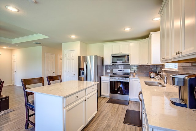 1805 Elderberry St, Royse City, TX 75189 - kitchen featuring stainless steel appliances, a sink, a kitchen breakfast bar, backsplash, and light wood-style flooring