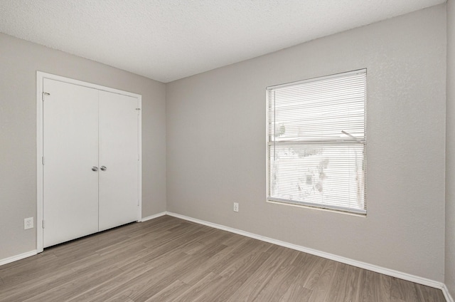 912 Brae Loch Dr, Dallas, TX 75217 - unfurnished bedroom featuring light wood-type flooring, baseboards, and a closet