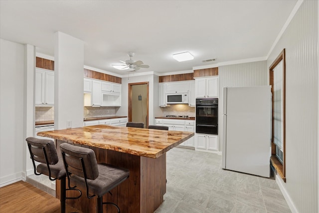 226 Hillcrest St, Sanger, TX 76266 - kitchen with white appliances, a warming drawer, wooden counters, tasteful backsplash, and white cabinets