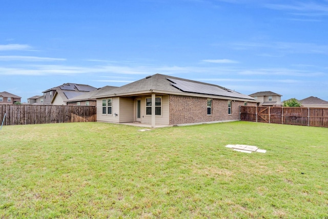 1408 Sebastian Dr, Forney, TX 75126 - rear view of property with roof mounted solar panels, brick siding, and a patio