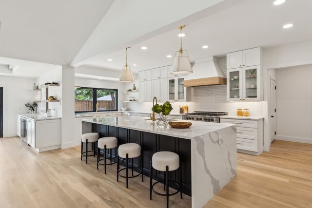 4162 Allencrest Ln, Dallas, TX 75244 - kitchen with custom range hood, a large island, light wood finished floors, decorative backsplash, and recessed lighting