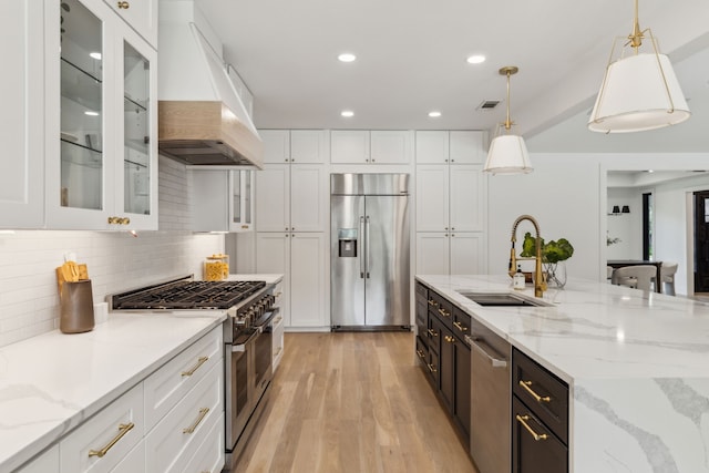4162 Allencrest Ln, Dallas, TX 75244 - kitchen featuring premium appliances, a sink, premium range hood, white cabinets, and light wood-style floors