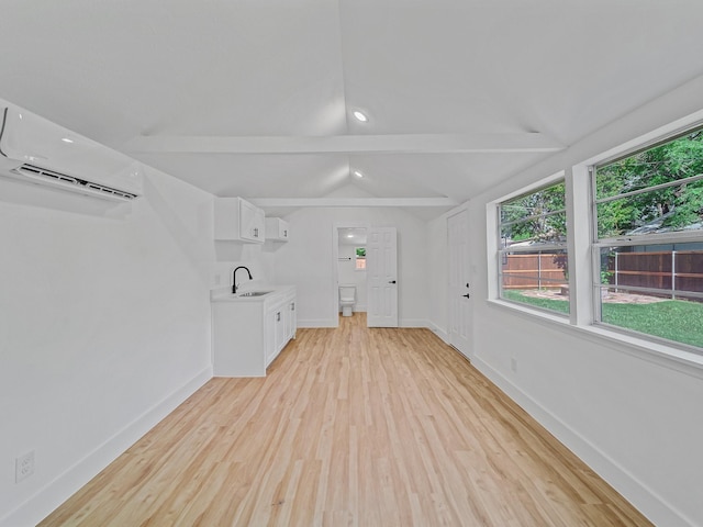 209 S Marlborough Ave, Dallas, TX 75208 - unfurnished living room with a sink, a wall mounted AC, light wood finished floors, and baseboards