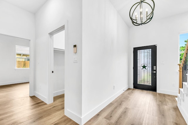 4017 Carl St, Dallas, TX 75210 - foyer entrance with a chandelier, stairway, light wood finished floors, and baseboards