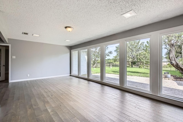 8 Canyon Ridge Dr, Fate, TX 75087 - empty room featuring baseboards, a textured ceiling, and dark wood-type flooring