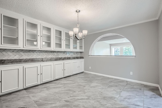 8 Canyon Ridge Dr, Fate, TX 75087 - kitchen featuring ornamental molding, tasteful backsplash, baseboards, a chandelier, and glass insert cabinets