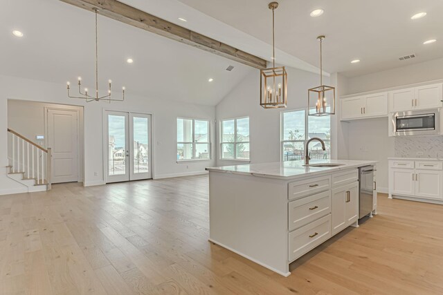 14448 Walsh, Aledo, TX 76008 - kitchen with a chandelier, stainless steel appliances, a sink, beamed ceiling, and light wood-style floors