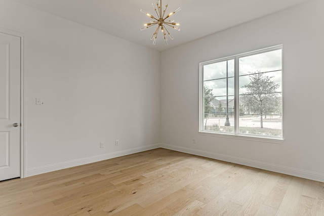 14448 Walsh, Aledo, TX 76008 - unfurnished room with light wood finished floors, a chandelier, and baseboards