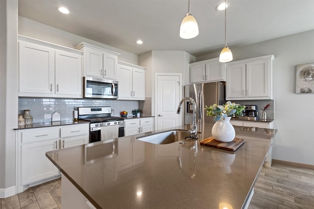 11413 Leeson St, Fort Worth, TX 76052 - kitchen featuring stainless steel appliances, a sink, dark countertops, a kitchen island with sink, and baseboards