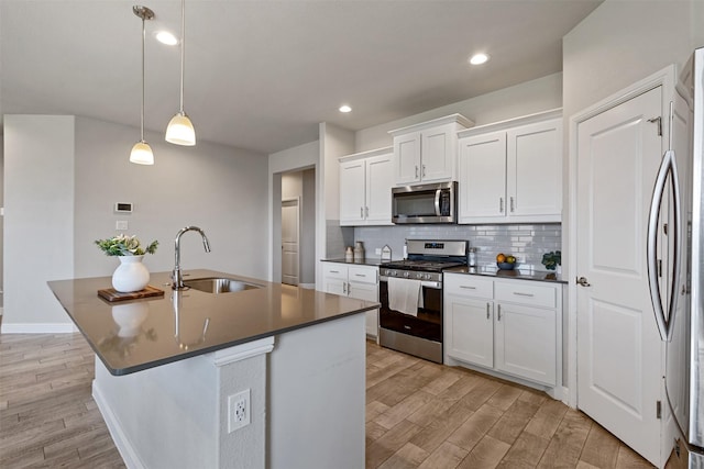 11413 Leeson St, Fort Worth, TX 76052 - kitchen with stainless steel appliances, a sink, dark countertops, light wood finished floors, and recessed lighting