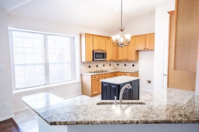 833 Tablerock Way, Lewisville, TX 75077 - kitchen with stainless steel microwave, a sink, a chandelier, light brown cabinets, and tasteful backsplash
