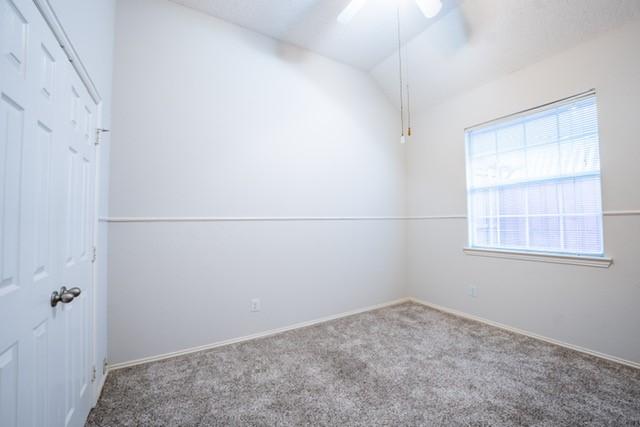 833 Tablerock Way, Lewisville, TX 75077 - empty room featuring ceiling fan, carpet flooring, lofted ceiling, and baseboards