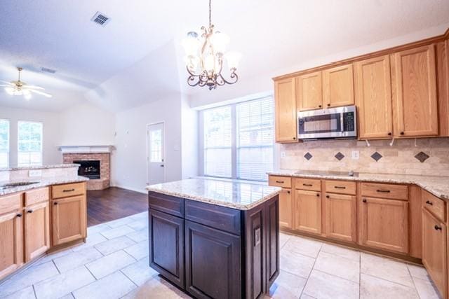 833 Tablerock Way, Lewisville, TX 75077 - kitchen featuring stainless steel microwave, vaulted ceiling, ceiling fan, backsplash, and a fireplace