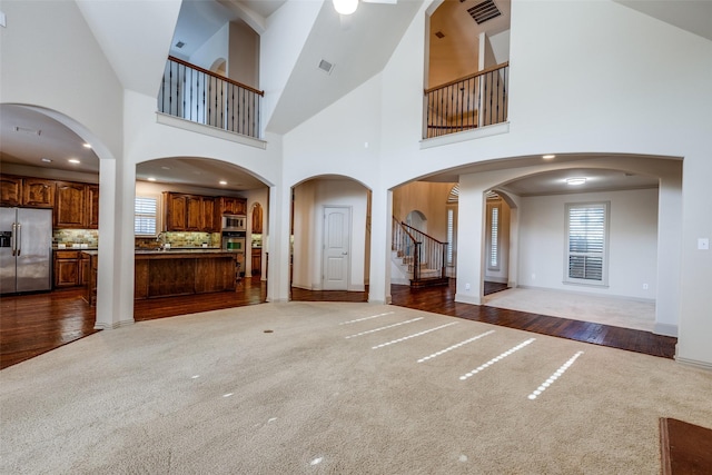 11257 Lamar Ln, Frisco, TX 75033 - unfurnished living room featuring carpet floors, plenty of natural light, stairway, and a towering ceiling