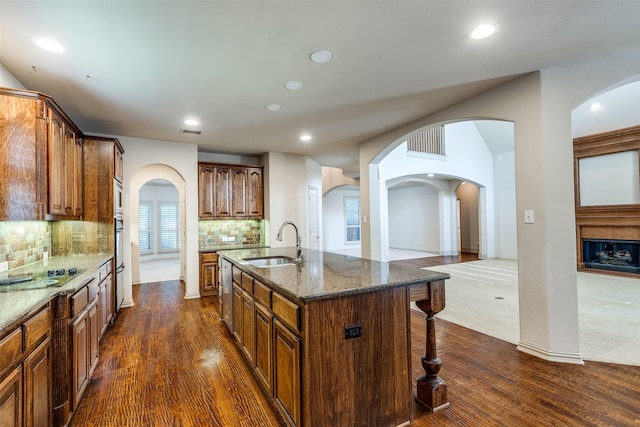 11257 Lamar Ln, Frisco, TX 75033 - kitchen featuring a sink, a breakfast bar, dark wood-type flooring, recessed lighting, and dark stone counters