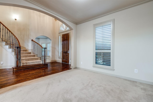 11257 Lamar Ln, Frisco, TX 75033 - entrance foyer with arched walkways, carpet flooring, stairs, crown molding, and baseboards