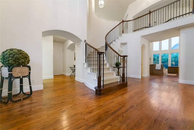 1503 Willingham Dr, Allen, TX 75013 - foyer entrance with arched walkways, a towering ceiling, wood finished floors, stairs, and baseboards