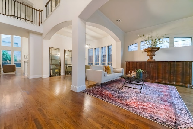 1503 Willingham Dr, Allen, TX 75013 - living area with crown molding, wood finished floors, a high ceiling, arched walkways, and baseboards