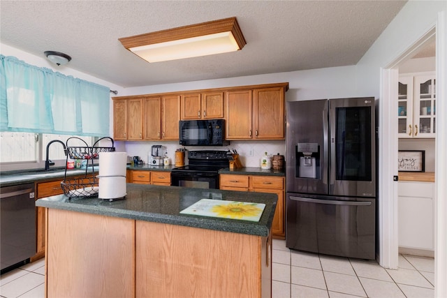 13412 Dove Ranch Rd, Fort Worth, TX 76262 - kitchen with black appliances, light tile patterned flooring, dark countertops, a kitchen island, and a textured ceiling