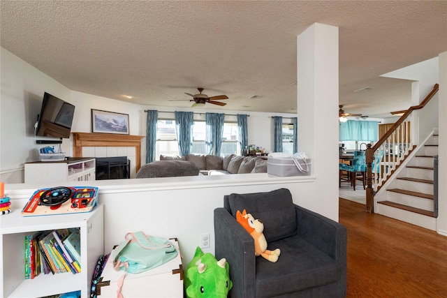 13412 Dove Ranch Rd, Fort Worth, TX 76262 - living area with a ceiling fan, wood finished floors, a textured ceiling, stairway, and a fireplace
