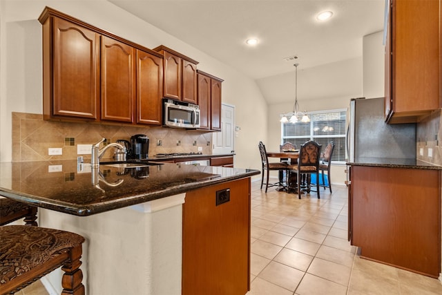 408 Castle St, Desoto, TX 75115 - kitchen with appliances with stainless steel finishes, a peninsula, a sink, a kitchen breakfast bar, and decorative backsplash