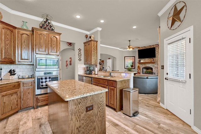 489 Roberts Run, Sherman, TX 75092 - kitchen featuring arched walkways, a center island, a ceiling fan, a peninsula, and stainless steel appliances