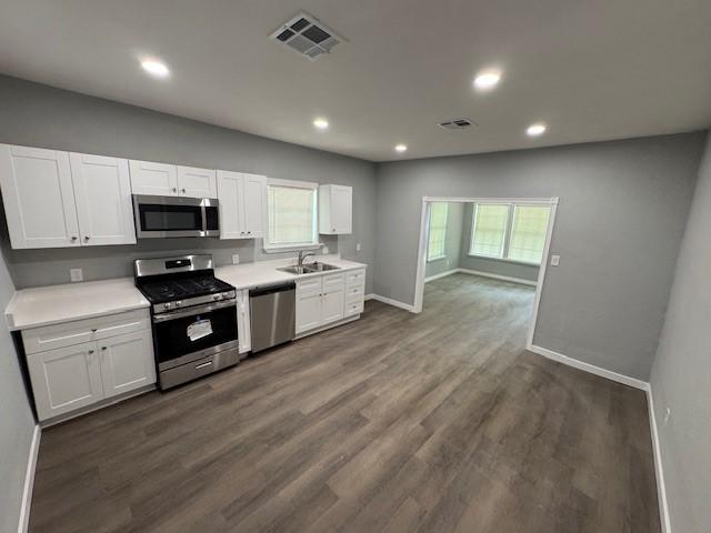1511 Gurley Ave, Waco, TX 76706 - kitchen with stainless steel appliances, a sink, baseboards, white cabinetry, and light countertops