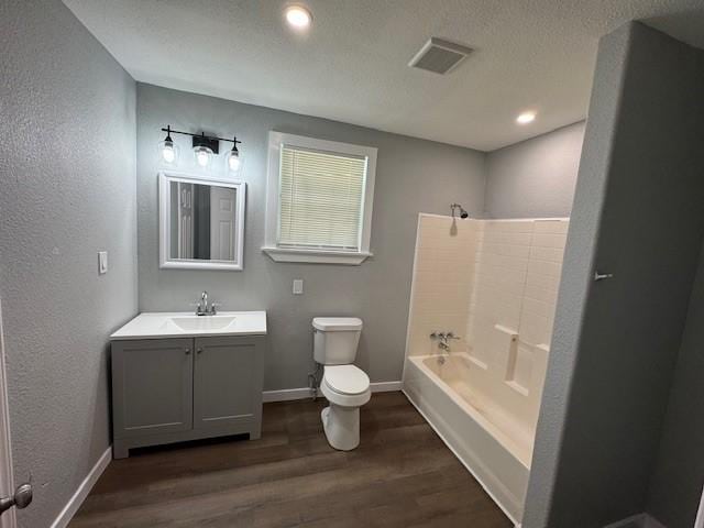 1511 Gurley Ave, Waco, TX 76706 - bathroom featuring toilet, vanity, wood finished floors, baseboards, and recessed lighting