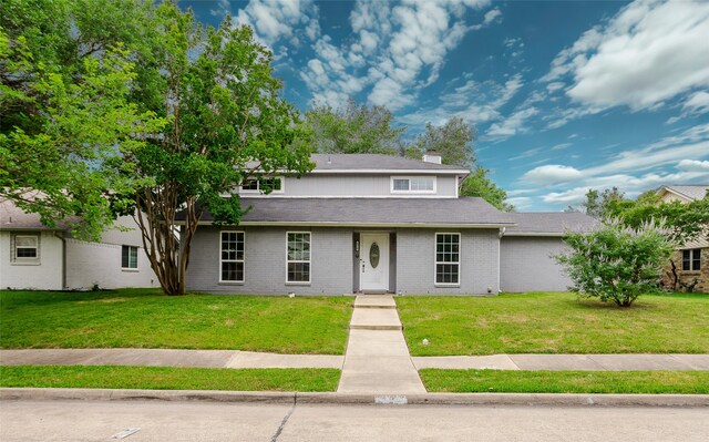 8910 Deerwood Dr, Rowlett, TX 75088 - view of front of home featuring a front lawn, a chimney, and brick siding