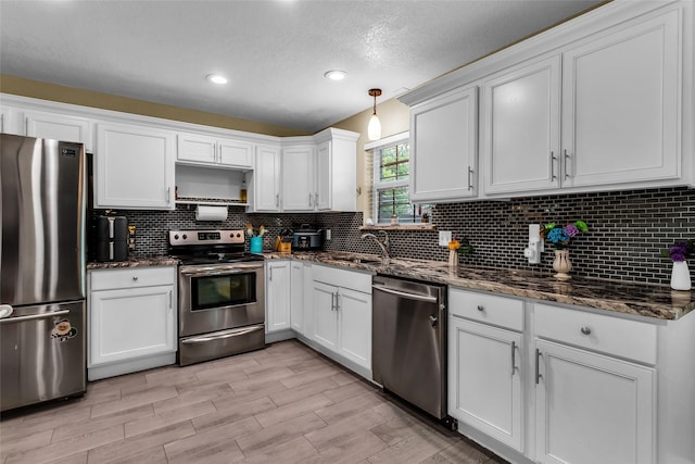 8910 Deerwood Dr, Rowlett, TX 75088 - kitchen featuring appliances with stainless steel finishes, white cabinetry, tasteful backsplash, a textured ceiling, and recessed lighting
