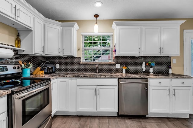 8910 Deerwood Dr, Rowlett, TX 75088 - kitchen with appliances with stainless steel finishes, a sink, white cabinetry, decorative backsplash, and dark stone countertops