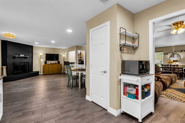 8910 Deerwood Dr, Rowlett, TX 75088 - living area with wood finished floors, recessed lighting, ceiling fan, baseboards, and a large fireplace