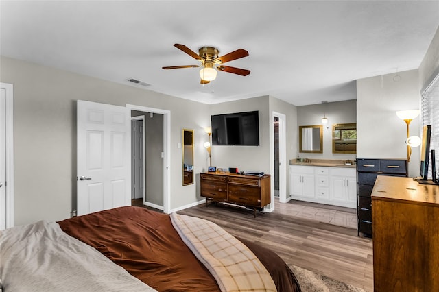 8910 Deerwood Dr, Rowlett, TX 75088 - bedroom with wood finished floors, baseboards, connected bathroom, and a ceiling fan