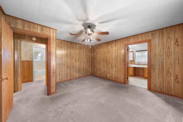 104 W Oak St, Yantis, TX 75497 - empty room featuring plenty of natural light, ceiling fan, light colored carpet, and wooden walls